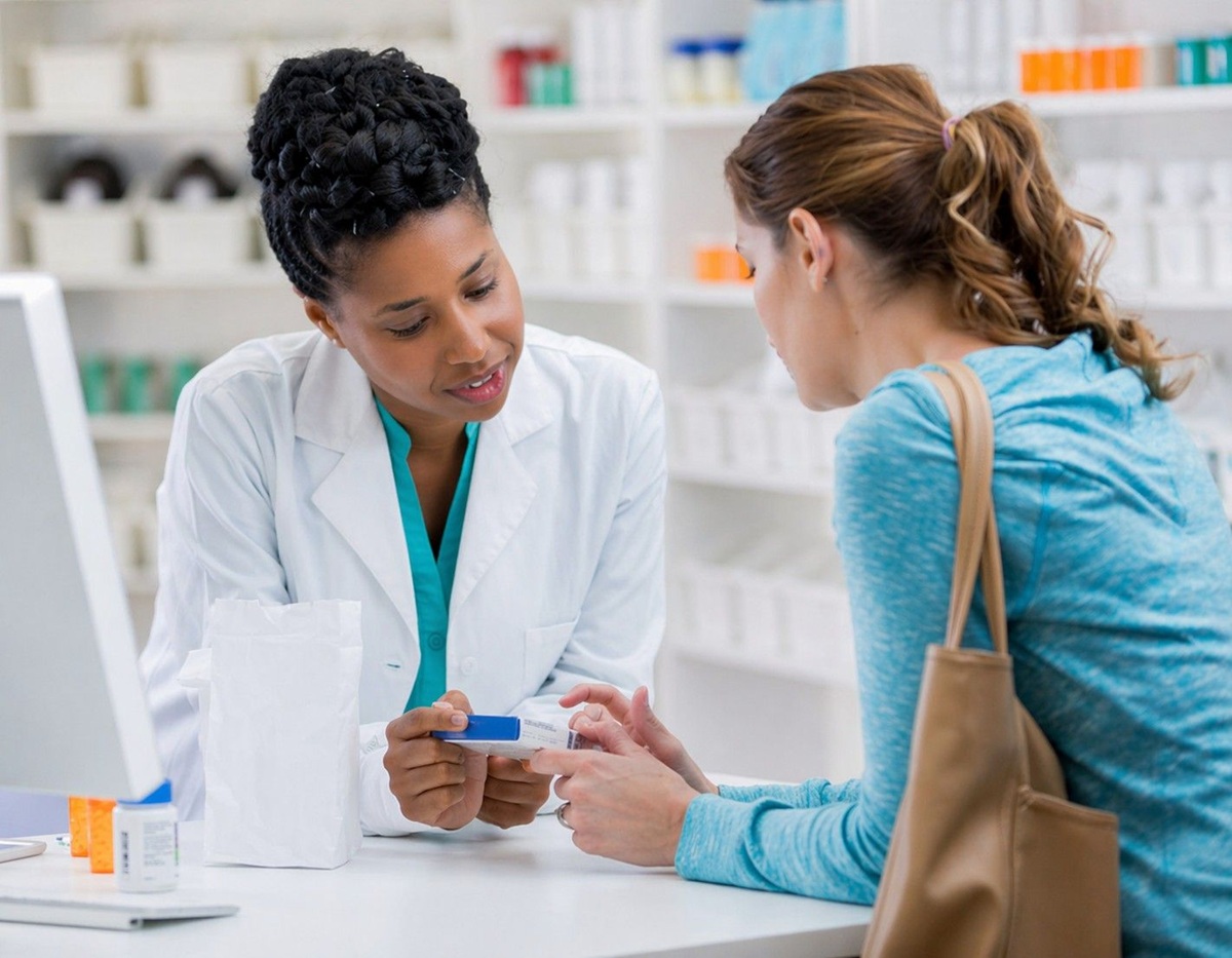 Pharmacist in white coat discussing medication plan with an elderly patient